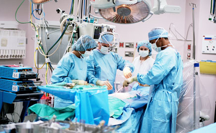 Surgical team operating under theatre lights