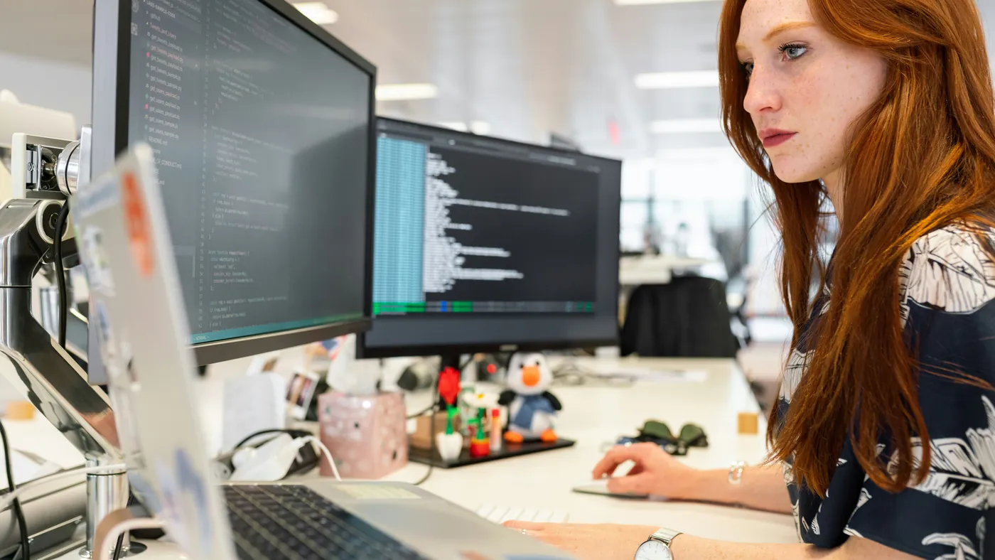An engineer at a multi-monitor workstation